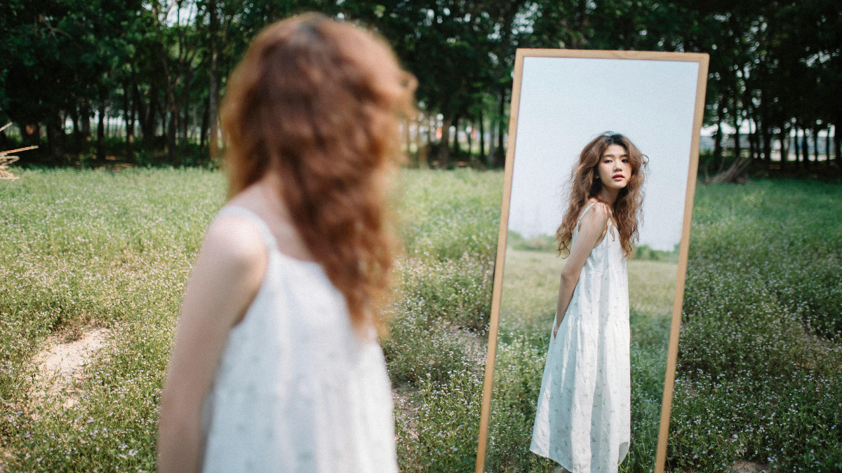 Building Self Acceptance When Single: women looks acceptingly at self image
